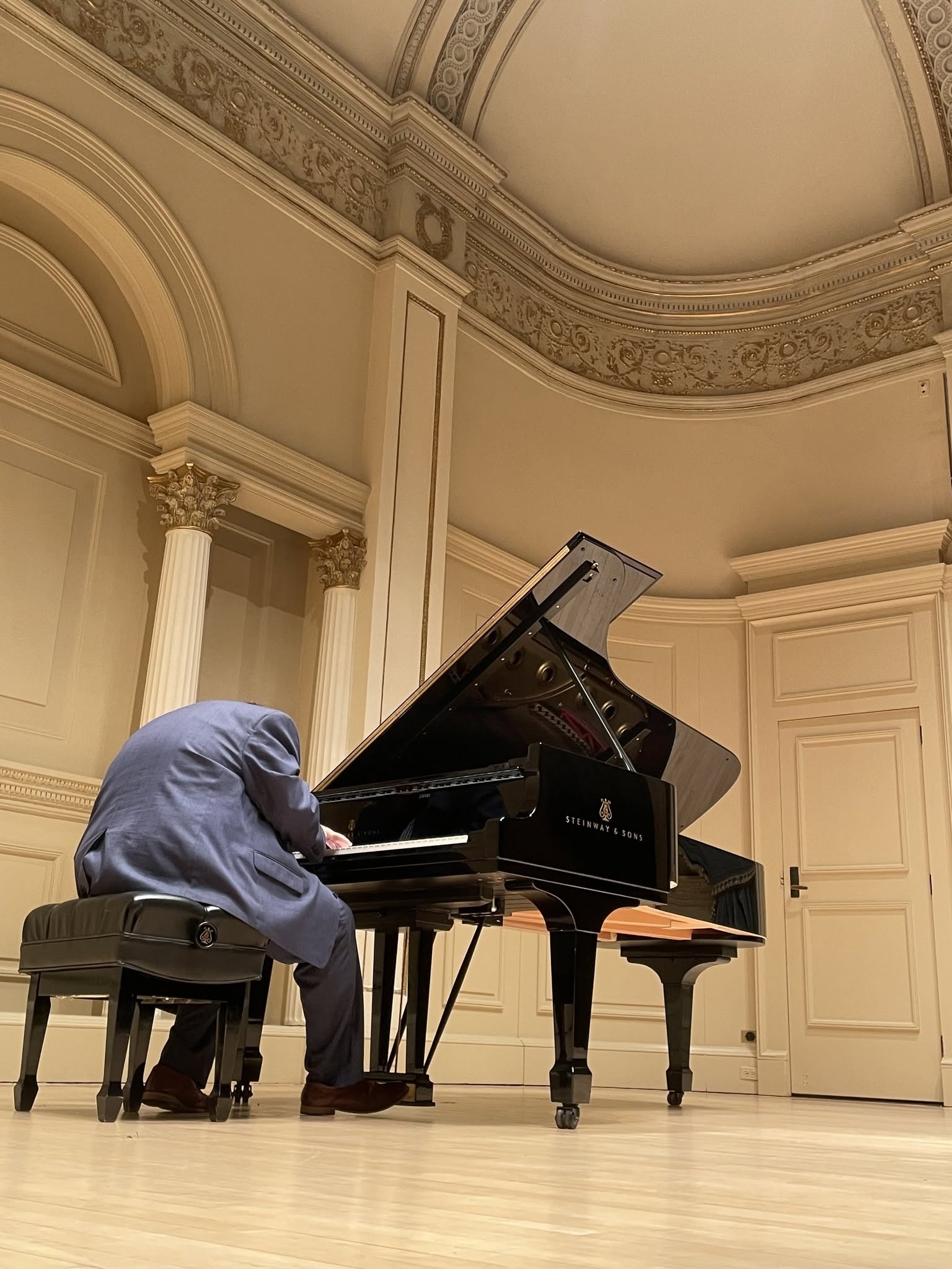 Nic Patterson performing at a grand piano at Carnegie Hall